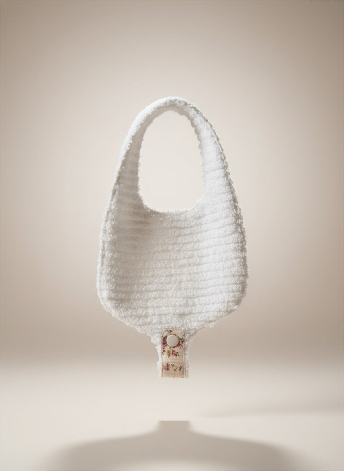 White Soothe & Snap pacifier bib with textured fabric and floral snap strap