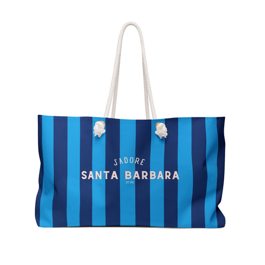 Blue and white striped weekender bag with rope handles and small flower ornaments