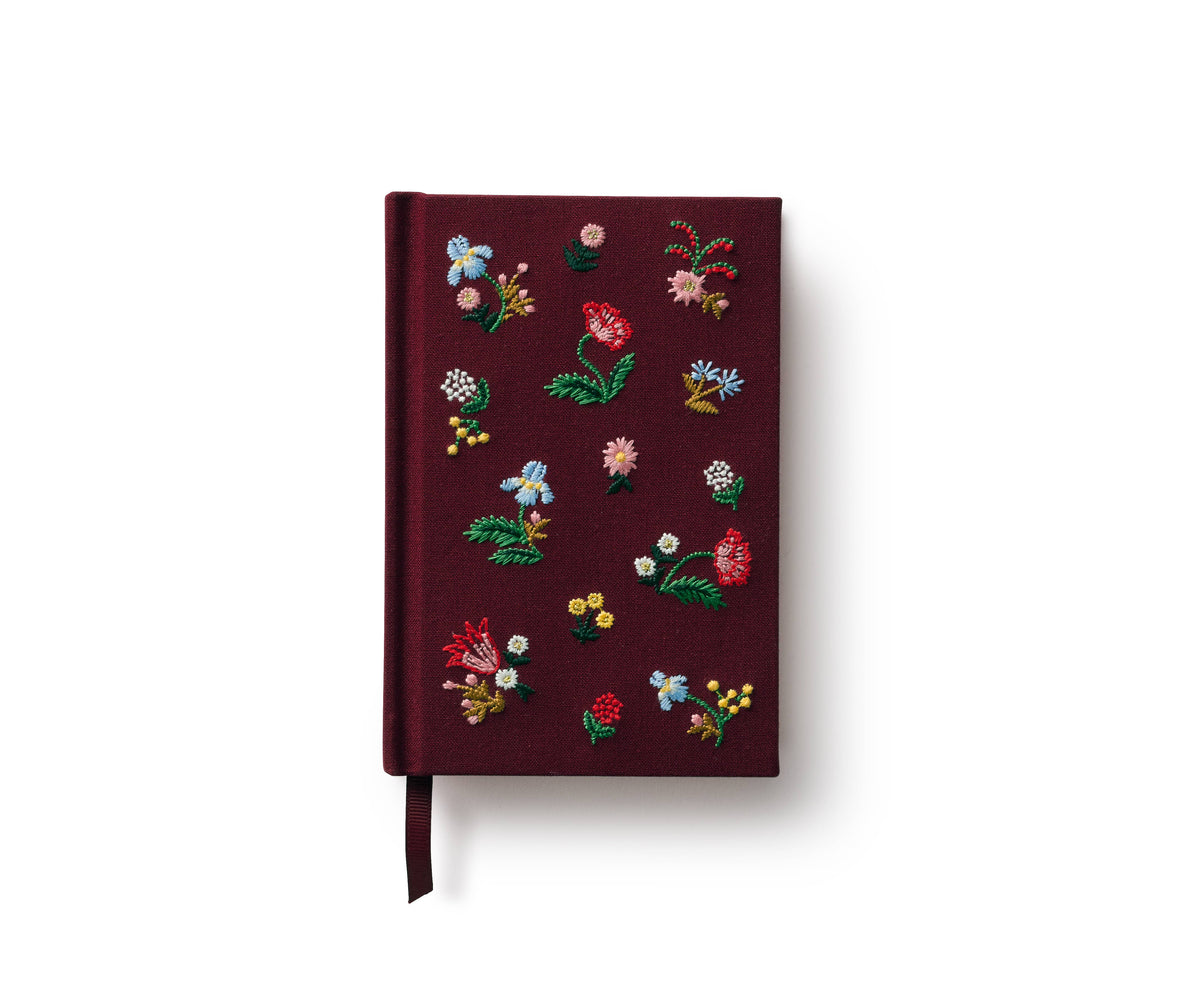 Mini embroidered journal with burgundy cover, colorful floral embroidery, and ribbon bookmark