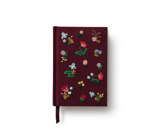 Mini embroidered journal with burgundy cover, colorful floral embroidery, and ribbon bookmark