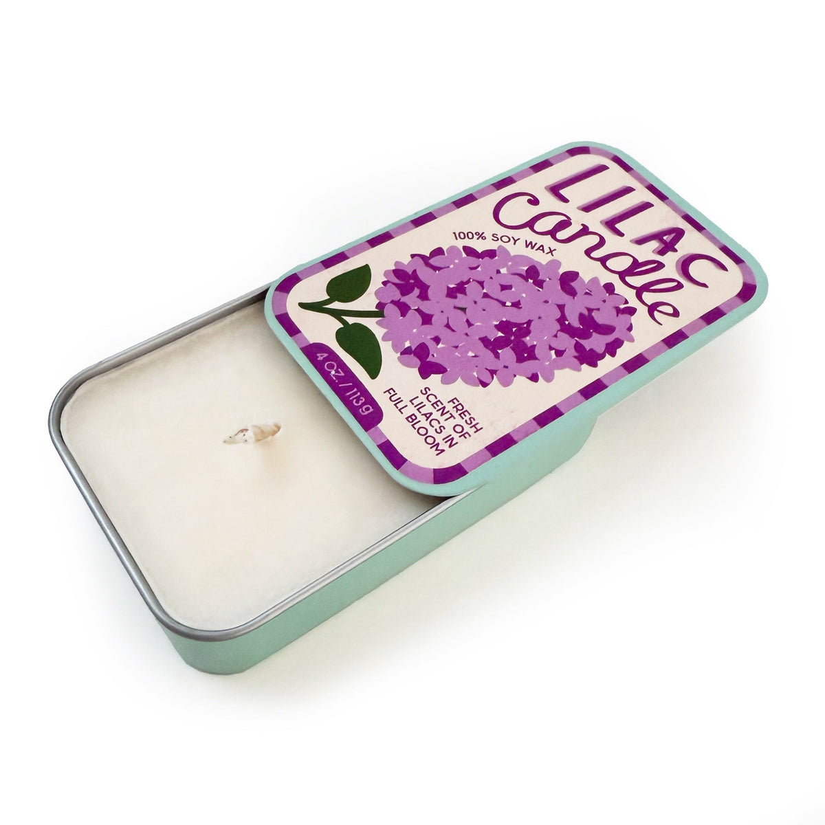 Lilac soy candle tin open, showing white wax with wick; purple label on mint base.