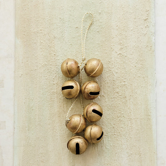 Hanging gold metal jingle bell cluster with white and gold cord, eight bells