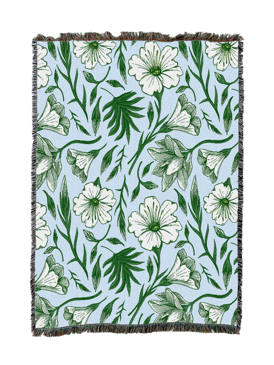 Floral throw blanket with green leafy pattern and white flowers, fringed edges