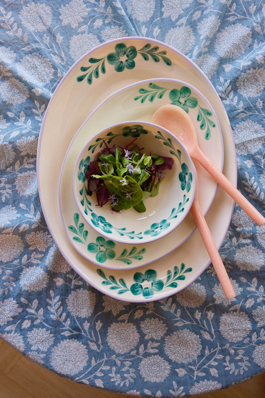Ceramic serving platter with green floral vine border and central leaf medallion