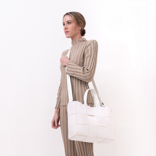 White tote bag with yellow lining on model, structured panels and top handles
