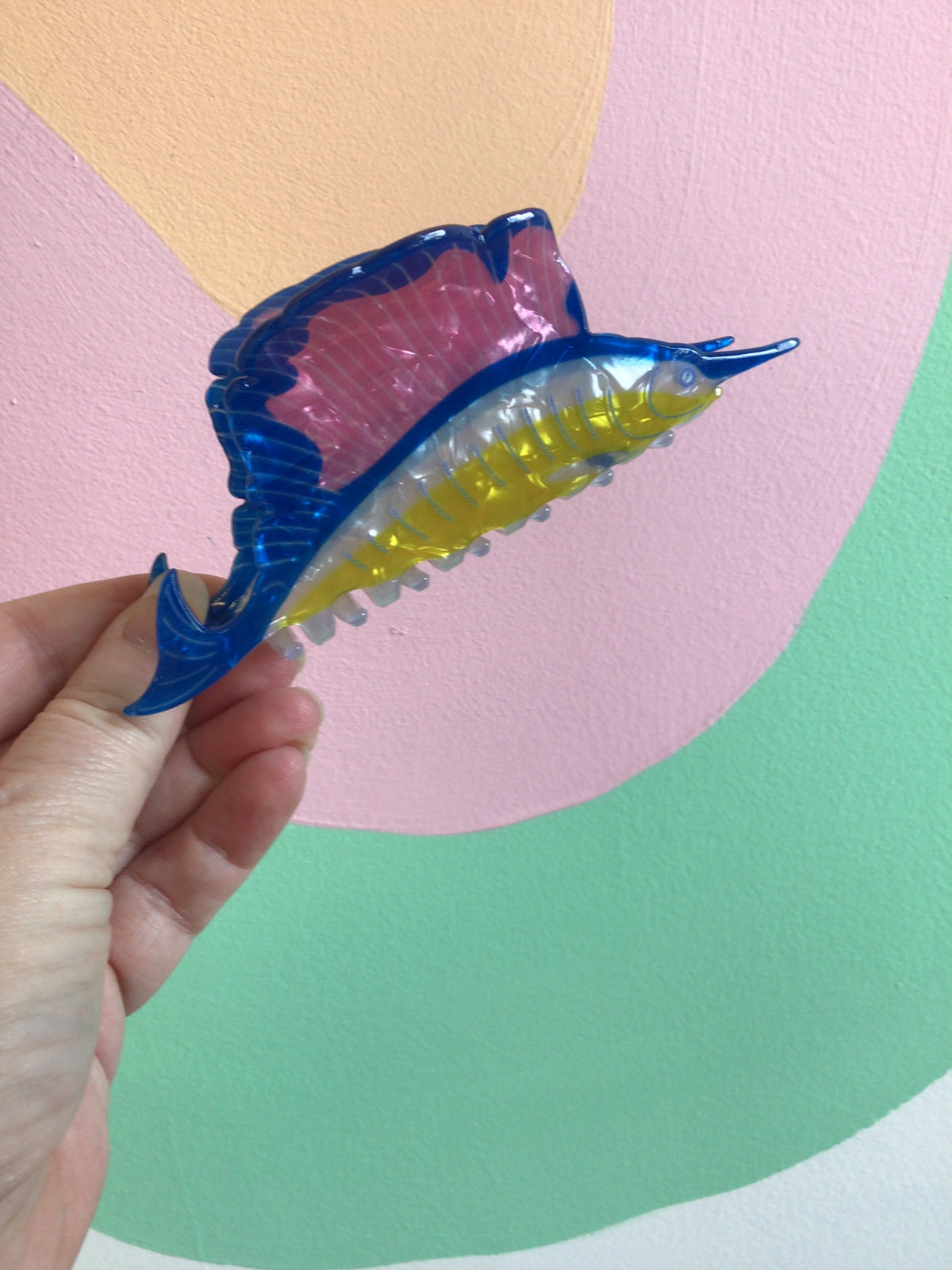 Blue fish hair claw with pink top and yellow-green belly, translucent comb.