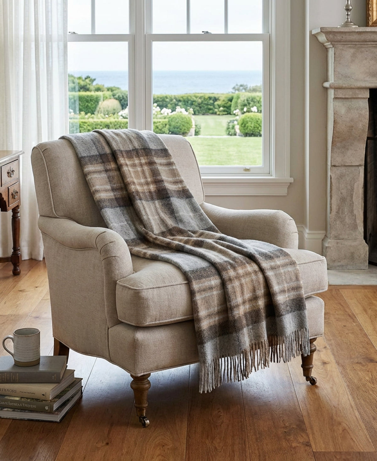 Plaid wool throw with fringed edges draped over beige armchair