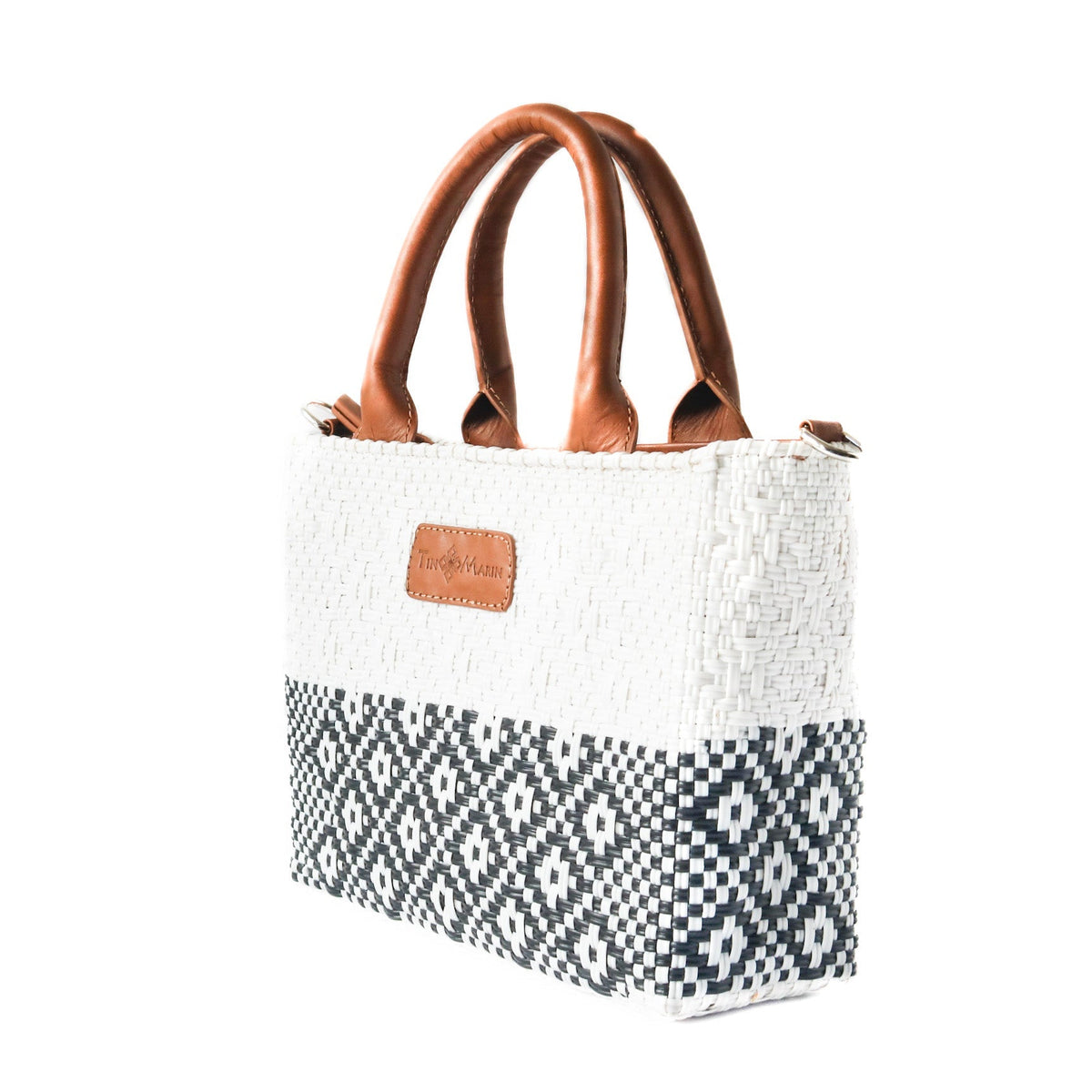 Small woven crossbody bag, white with black geometric band, tan leather handles and tag