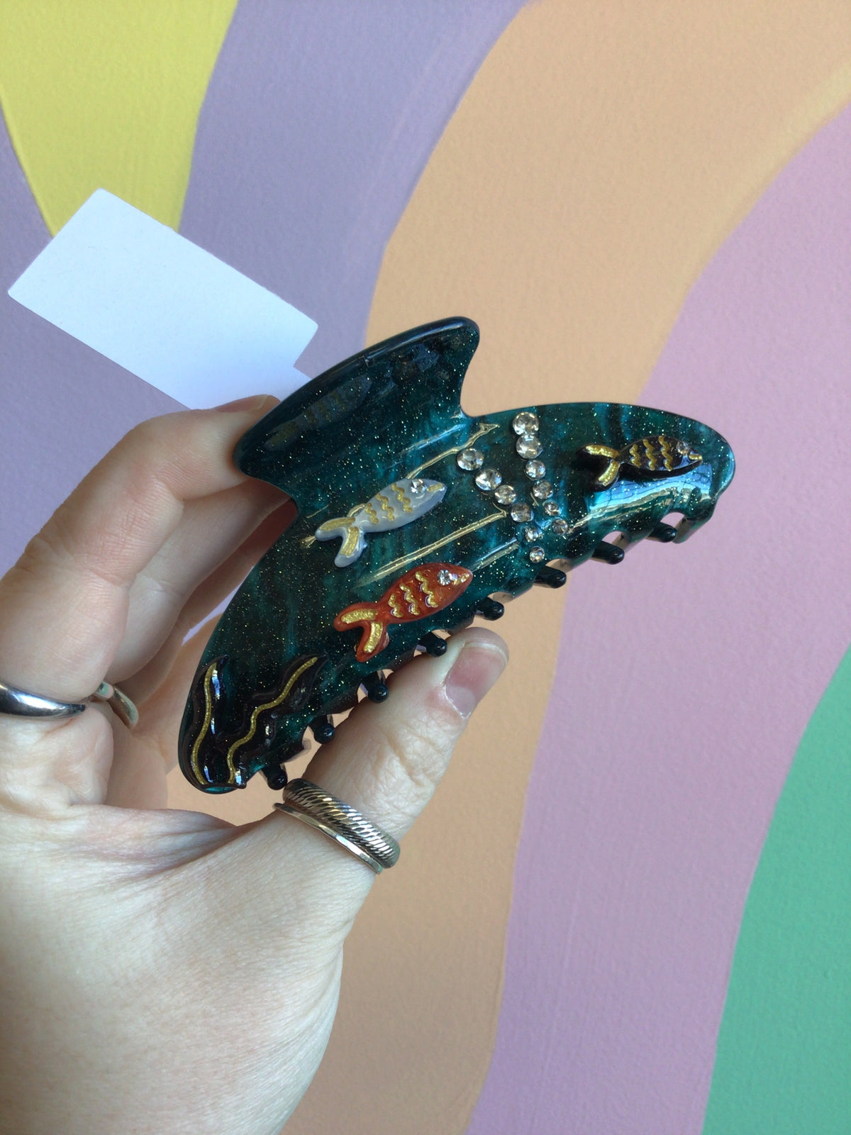 Dark blue fish-shaped hair claw with glitter dots and small orange-red fin details