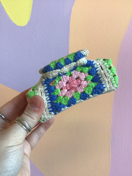 Crocheted hair claw with green, blue, and pink patchwork flowers