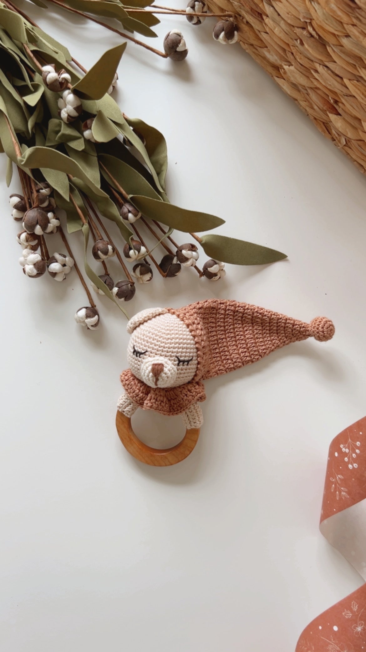 Teddy bear teether rattle with beige muzzle, brown body, and wooden ring on display