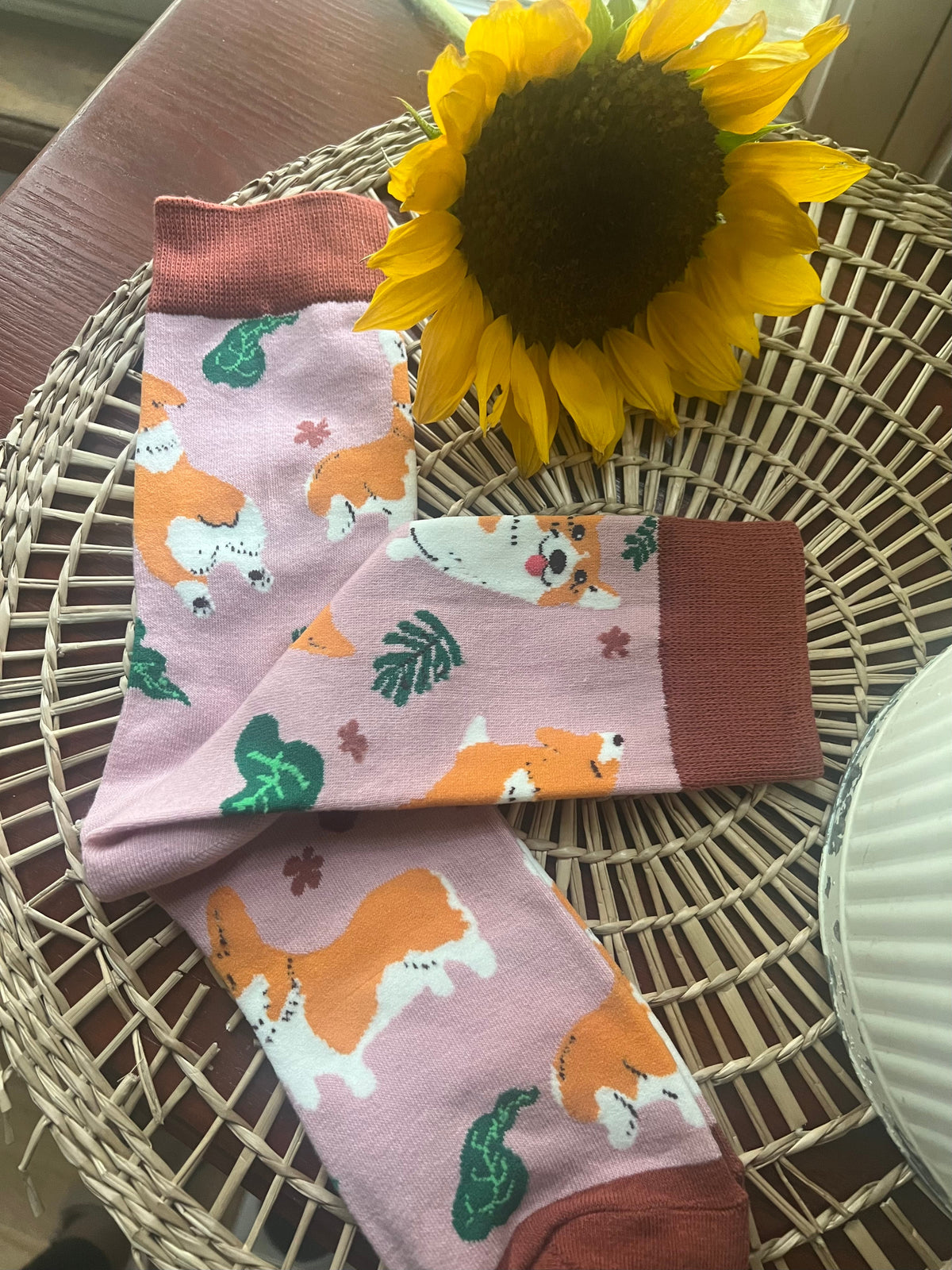 Corgi socks with pink cuffs, white-lavender fabric, orange dogs and green leaves