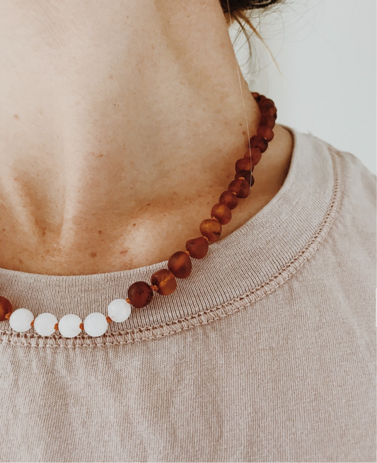 Brown amber bead necklace with small white moonstone beads on a cord