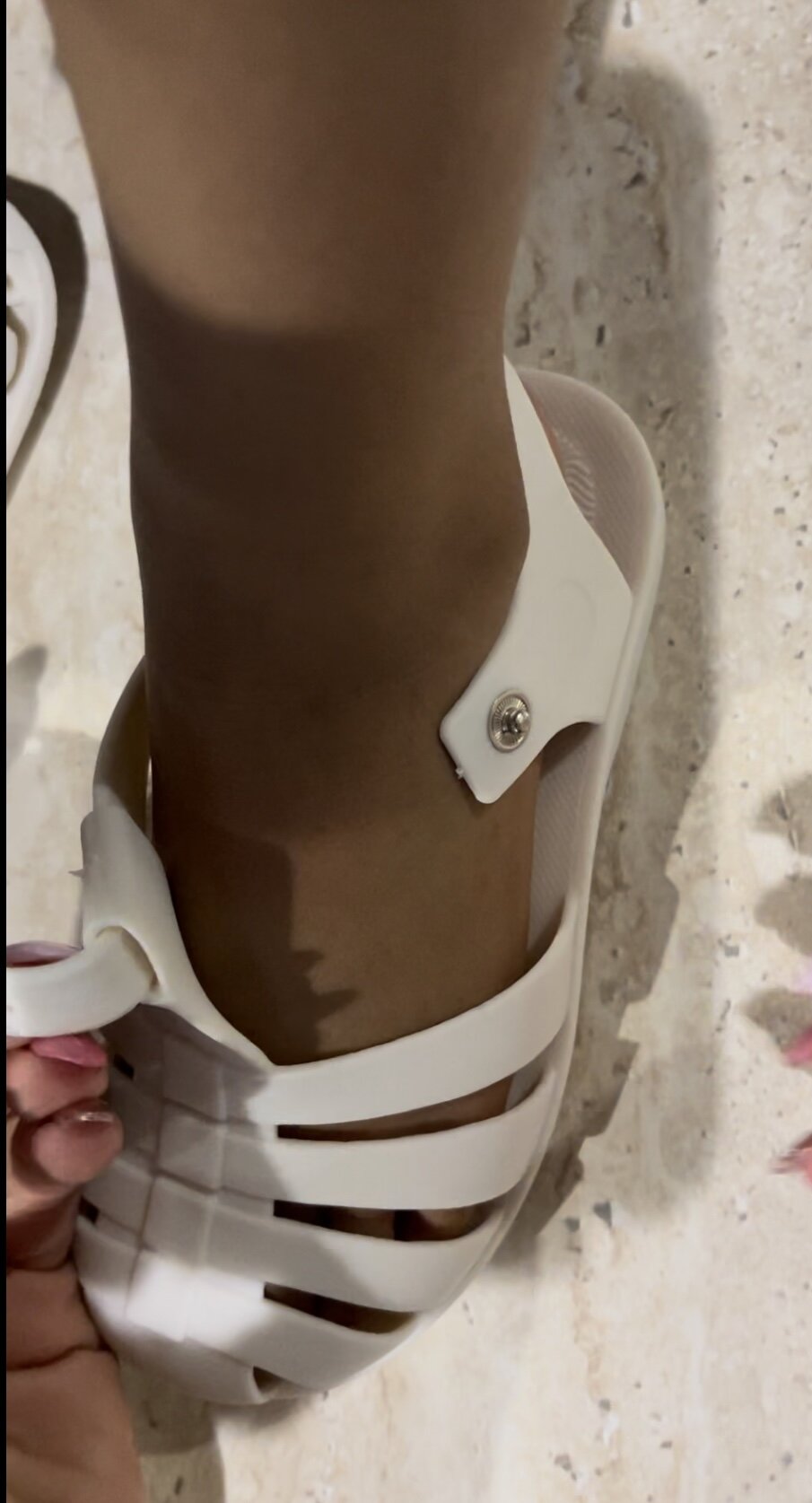 Kids' barefoot jelly sandals in cream on foot with buckle strap over instep