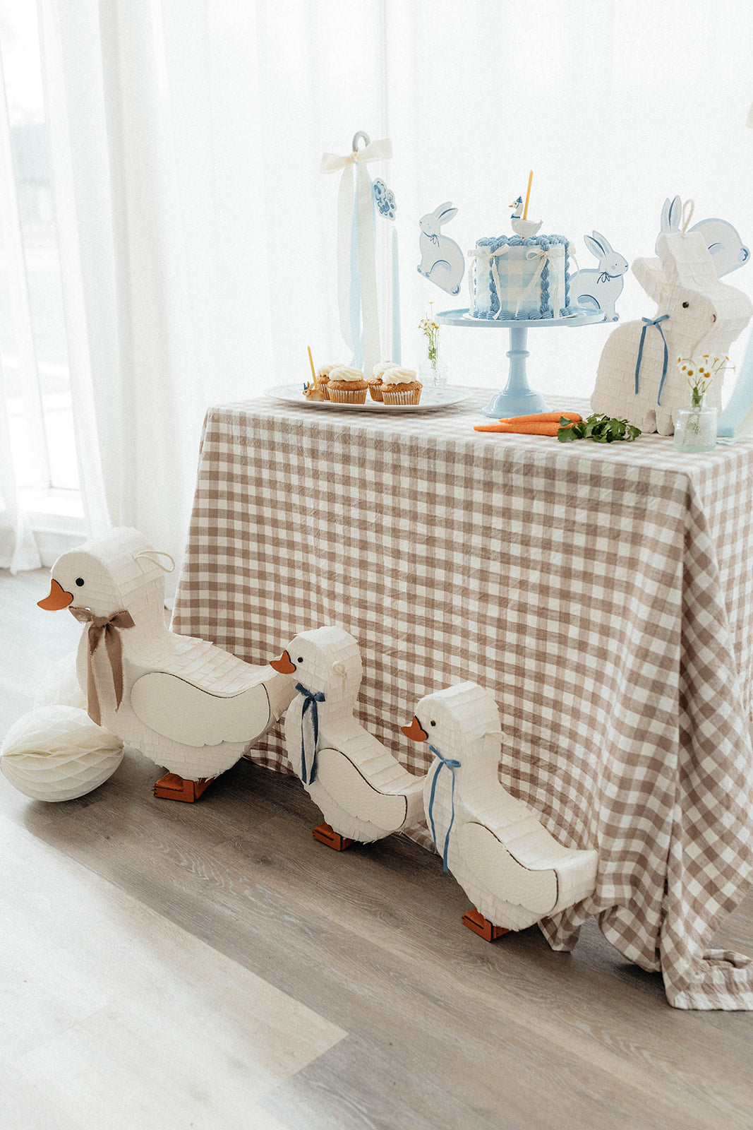 Duck piñata set in white with ribbon bows, shown in three sizes