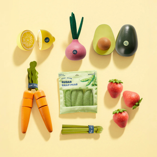 Assorted organic-style play food set with carrots, peas, radish, avocado, lemon, strawberries.
