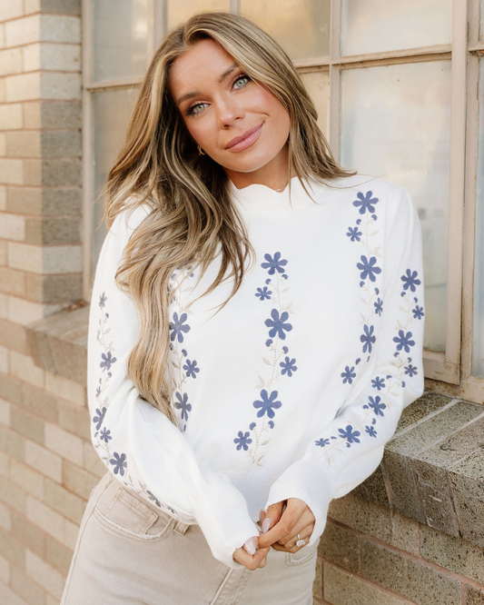 White cropped sweater with blue floral embroidery and scalloped hem