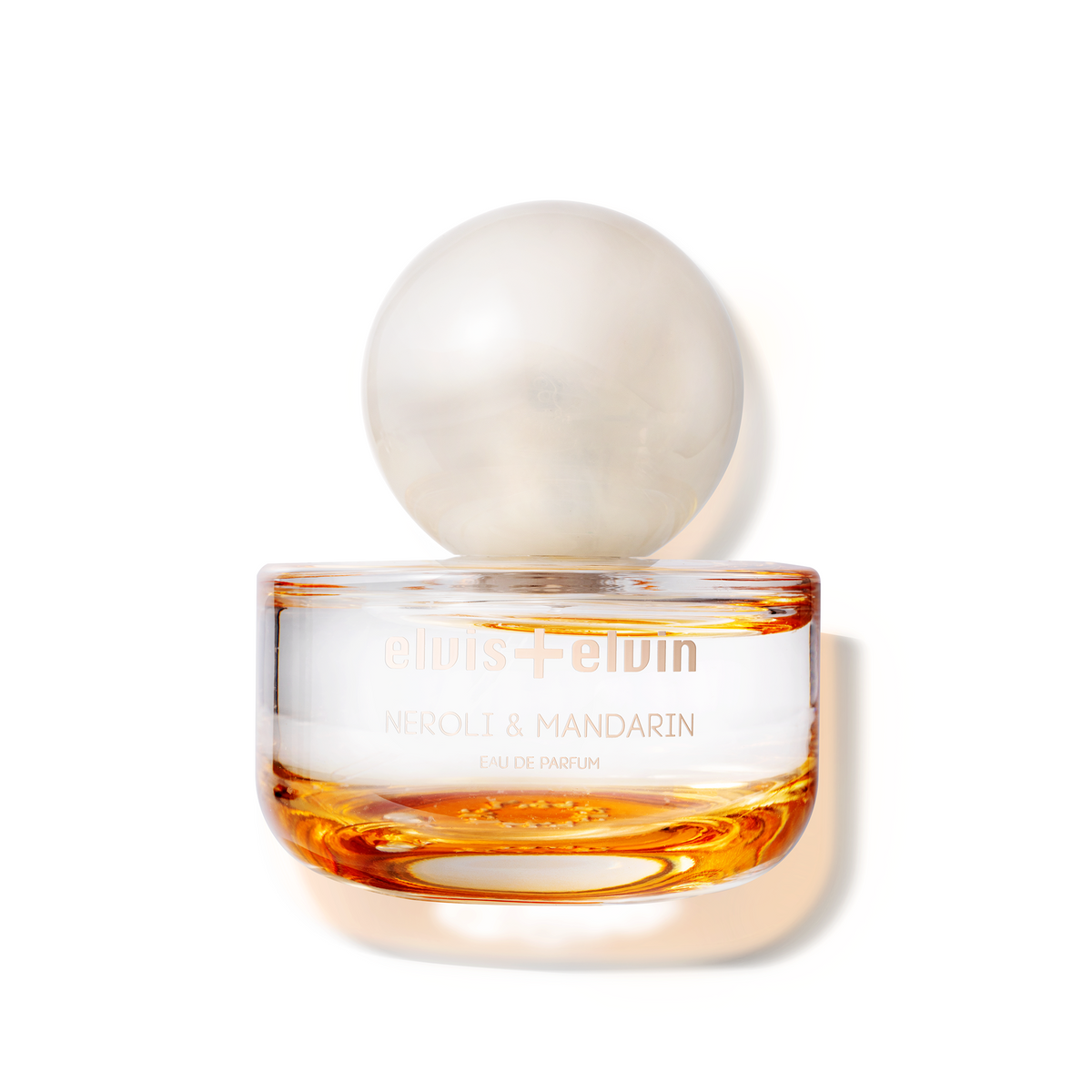 Neroli & mandarin eau de parfum bottle with round glass cap and amber liquid