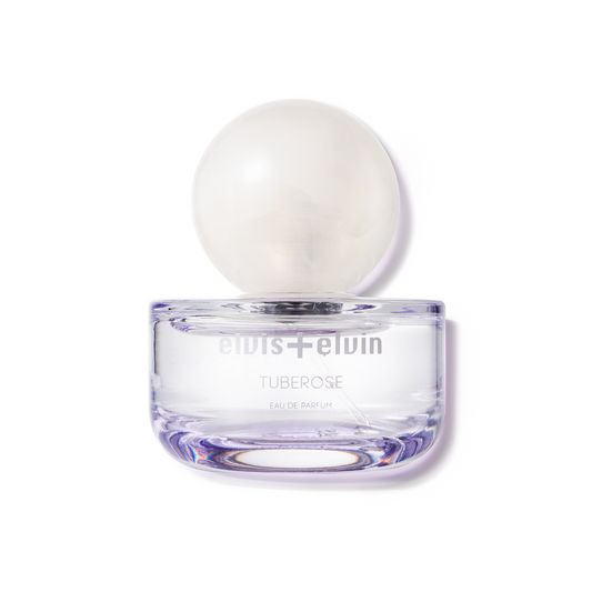 Tuberose eau de parfum bottle with round white cap in clear purple glass
