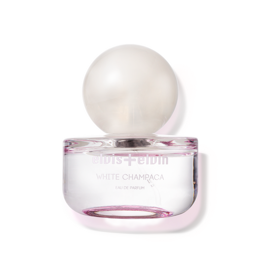 Eau de parfum bottle with rounded glass and “White Champaca” label, pink accents
