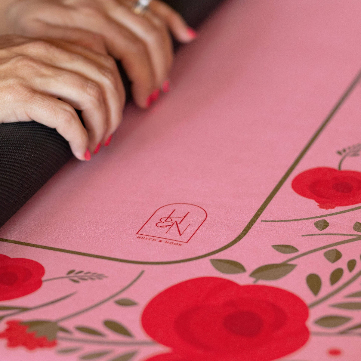 Pink floral mahjong mat close-up with brand logo and red rose leaf pattern
