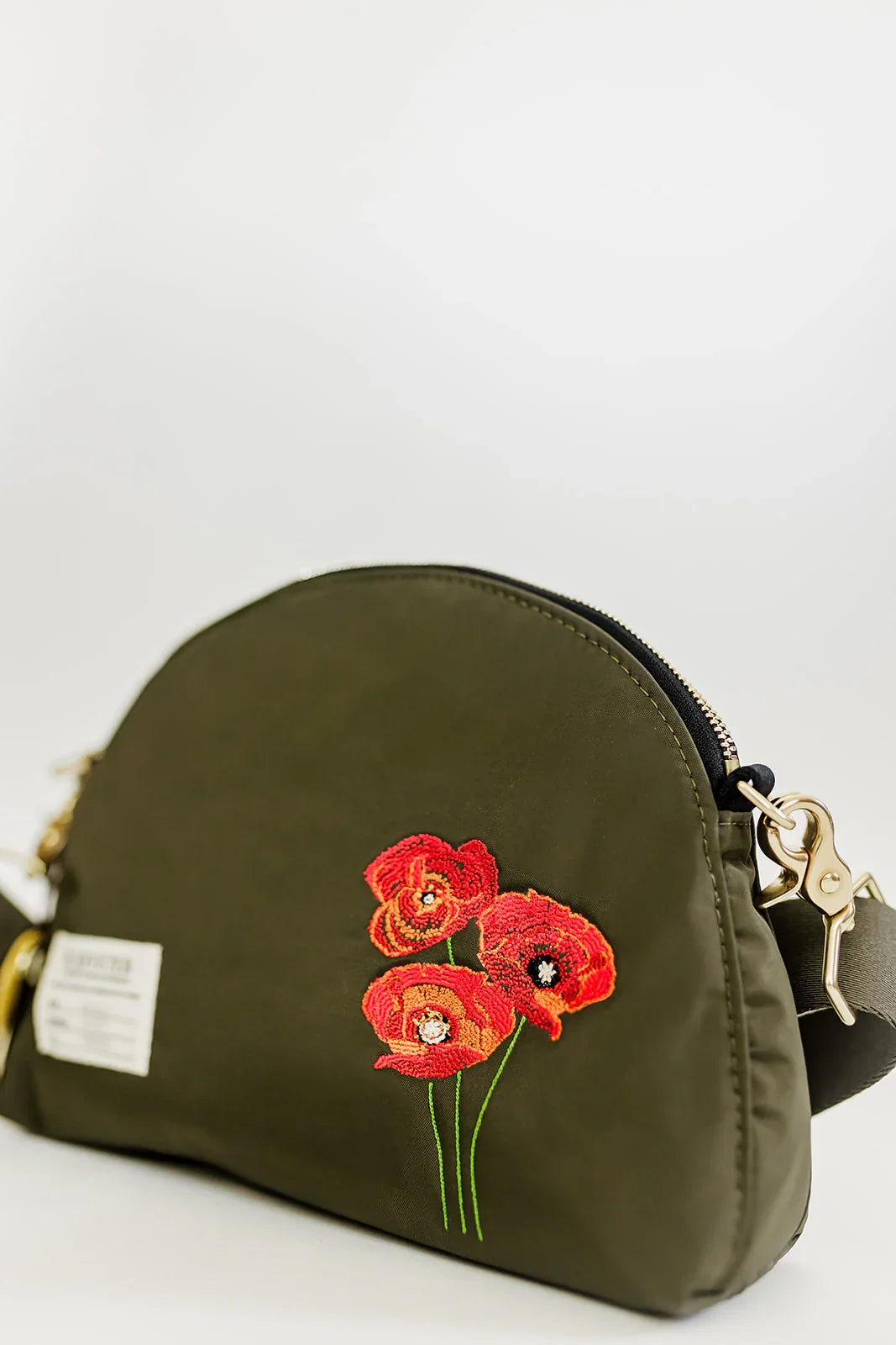 Olive dome crossbody bag side view with red poppy floral embroidery and gold clasp