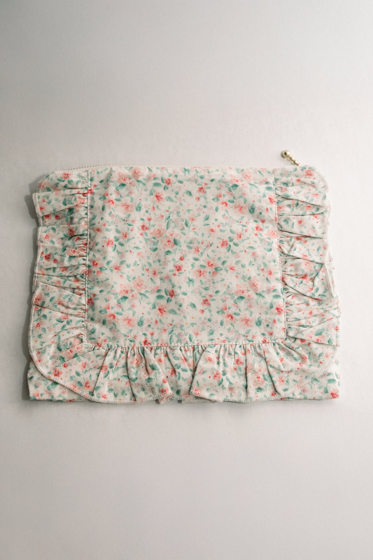 Pastel floral ruffle zip pouch with gathered front and zipper pull loop