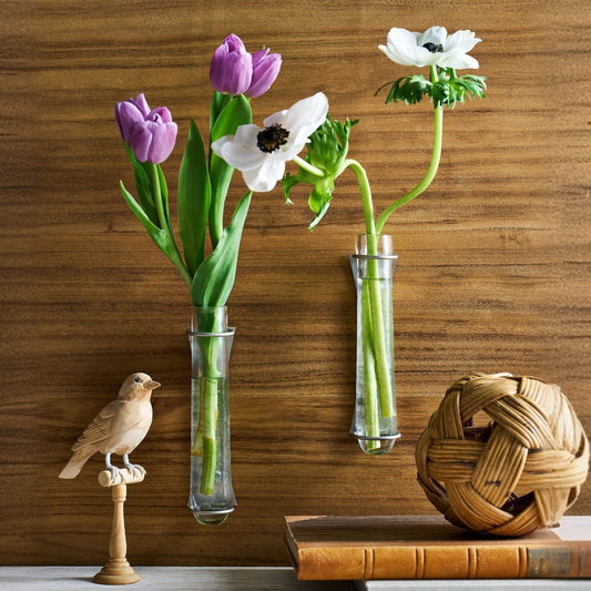 Set of 2 clear glass wall vases with metal wall brackets and floral stems