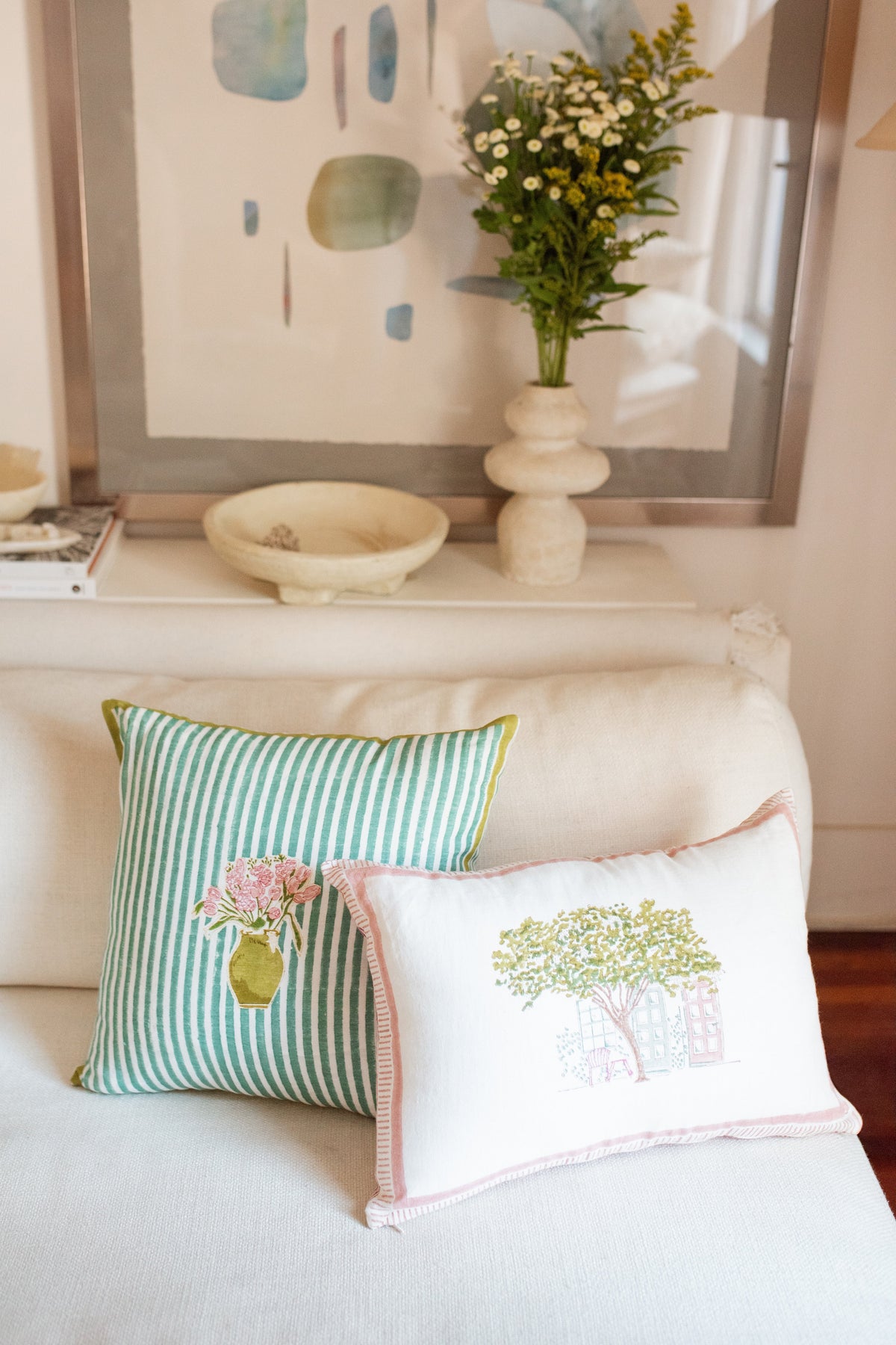 Green striped pillow on a sofa with floral bouquet applique and yellow trim