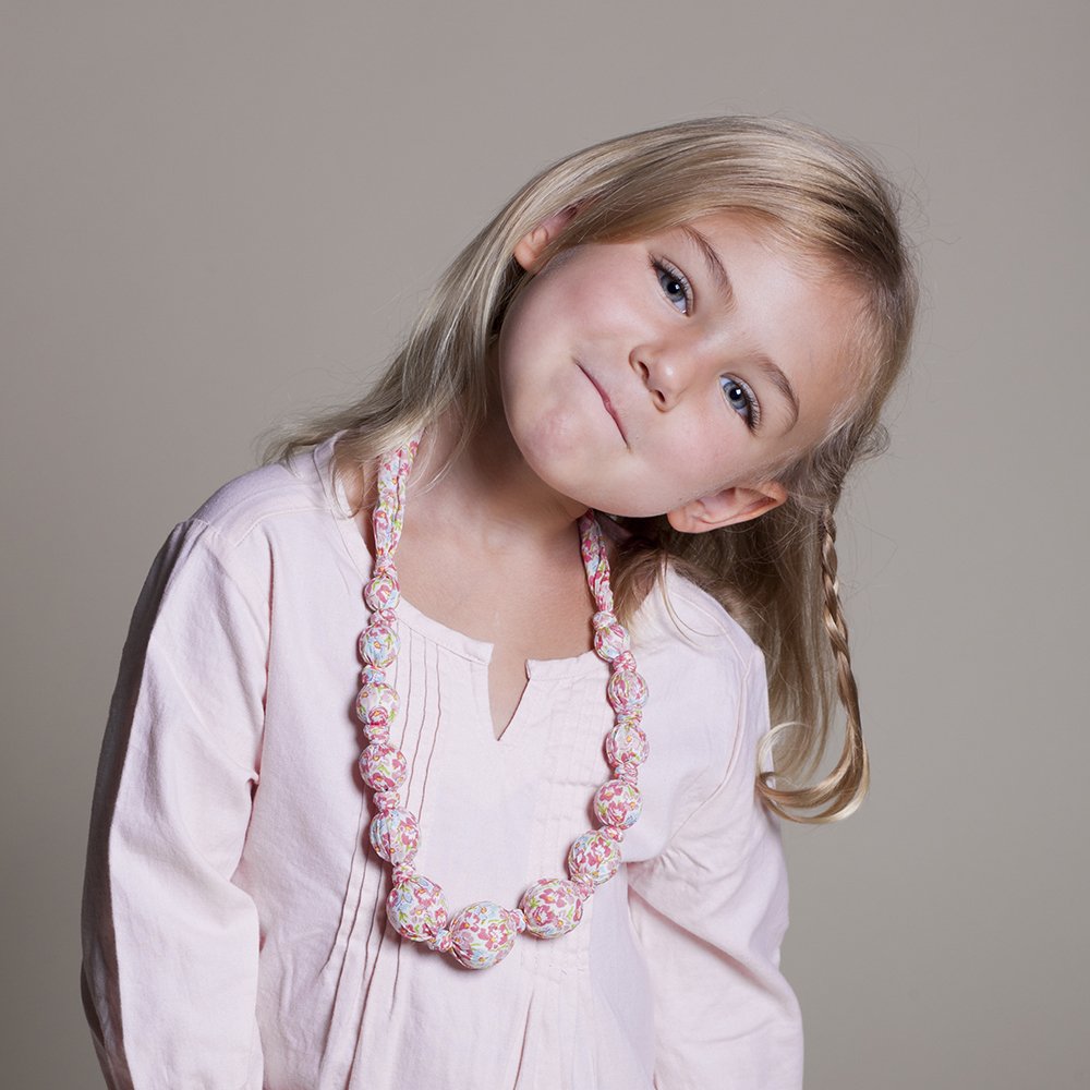 Girls' pink floral fabric necklace with covered beads, worn around the neck