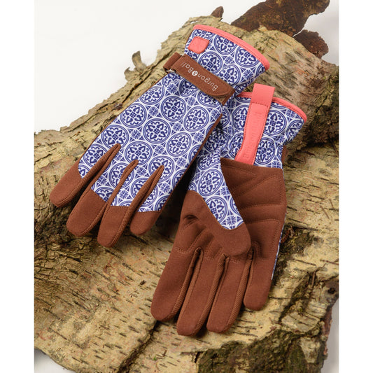 Garden gloves on bark: brown fingertips and palms, blue patterned back, coral wrist strap