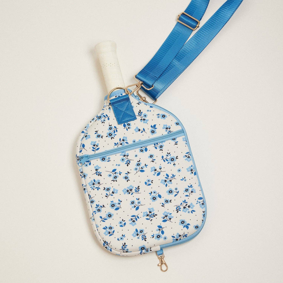Blue floral neoprene pickleball paddle bag with front zipper and adjustable shoulder strap