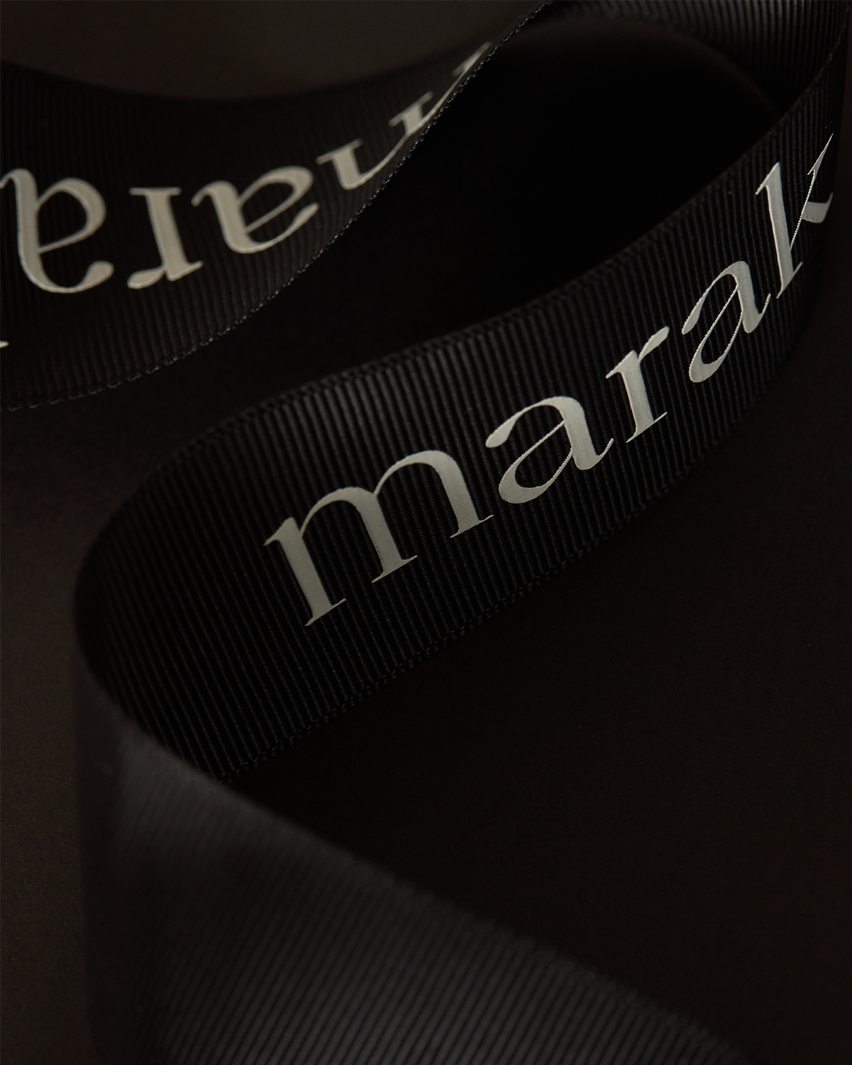 marak gift ribbon with pine text on black packaging