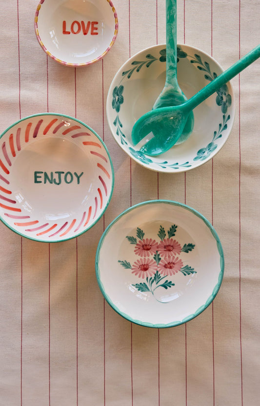 Ceramic salad bowls with green floral design and decorative rim, on display