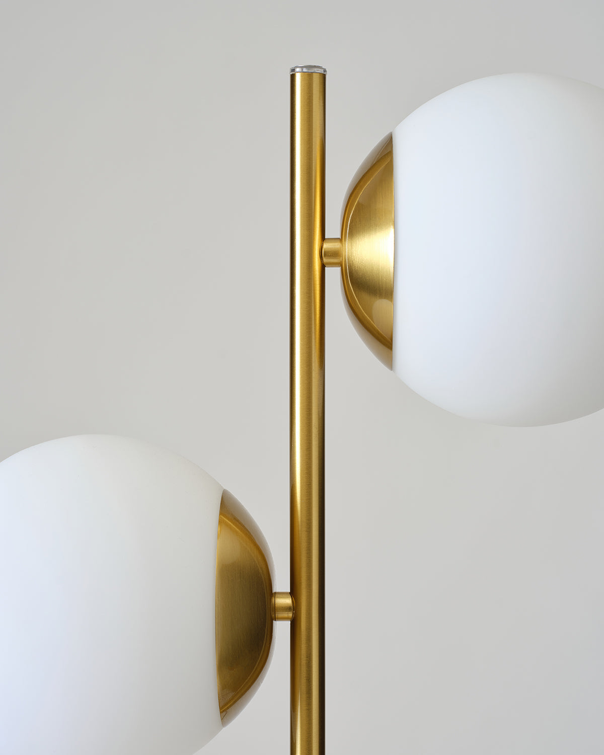 Brass two-globe lamp with two white shades on tall gold stem