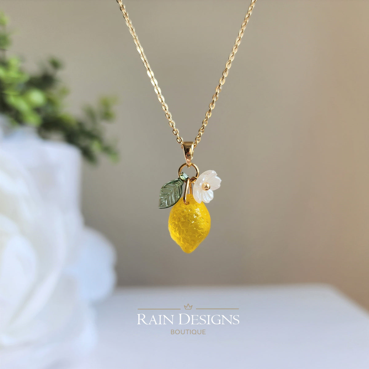 Gold chain lemon pendant necklace with white flower and green leaf charms