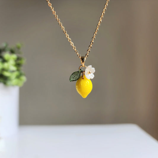 Gold chain lemon pendant necklace with white flower and green leaf detail