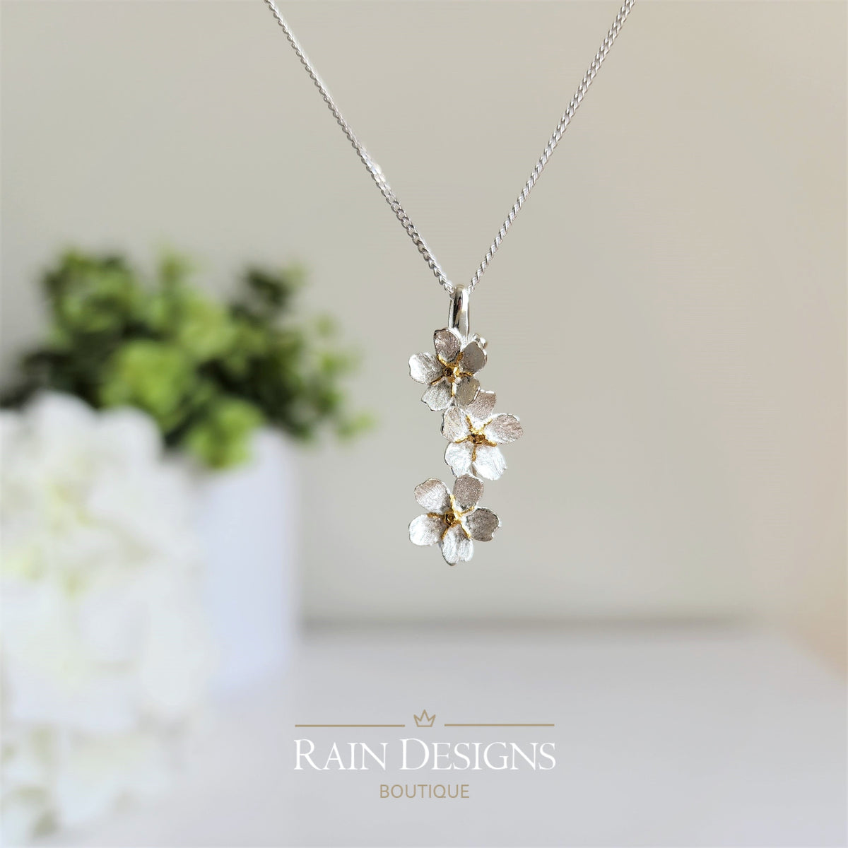 Silver forget-me-not flower necklace with clustered blossoms on a fine chain.