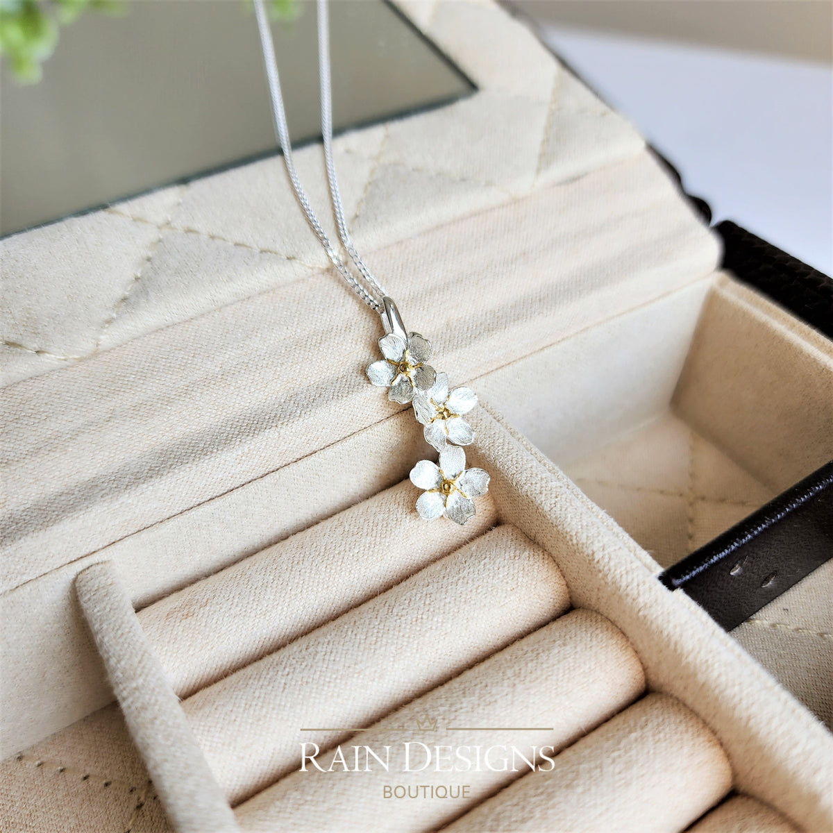 Silver forget-me-not flower necklace with clustered blossoms pendant on a fine chain.