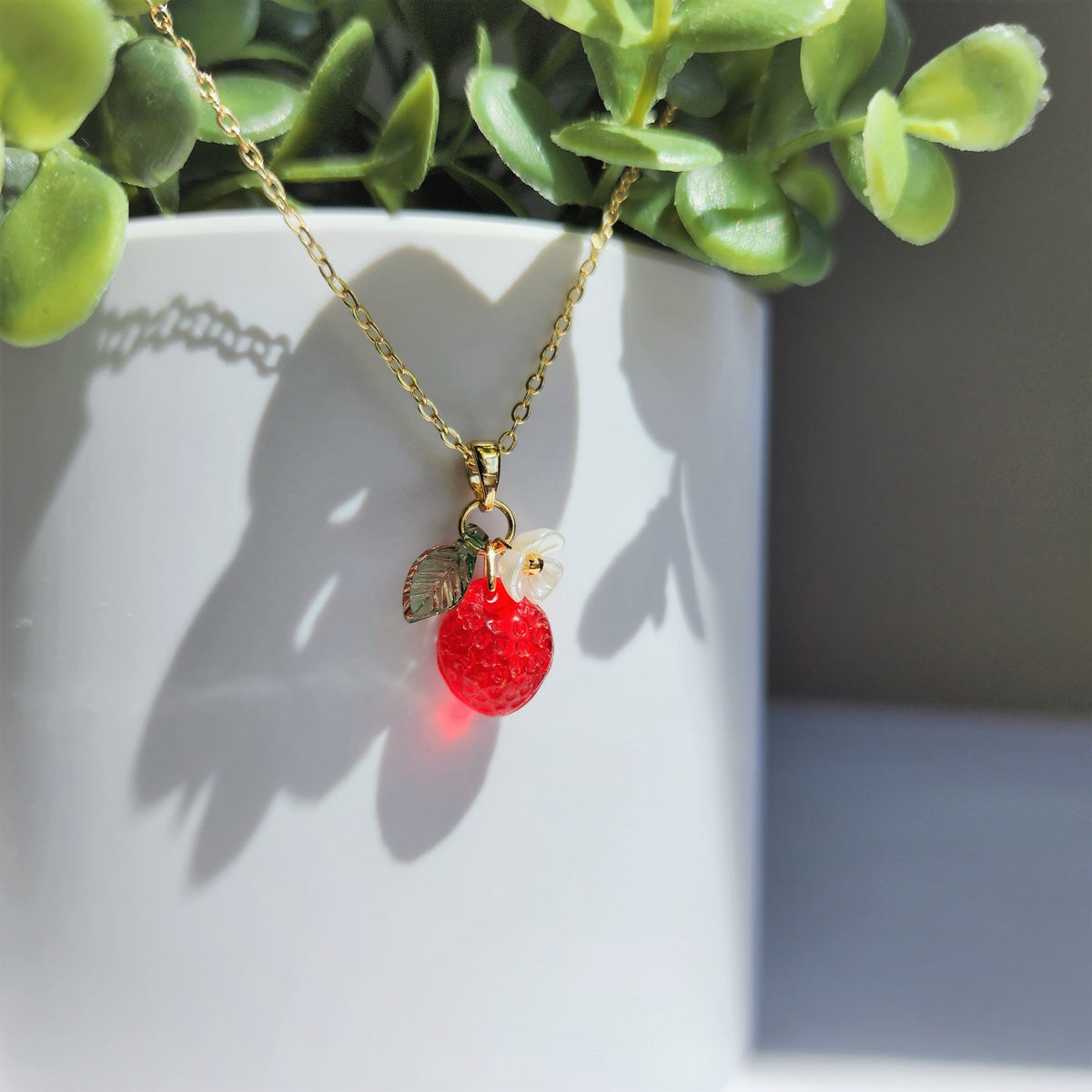 Gold strawberry fruit necklace with white flower and green leaf charm, full pendant