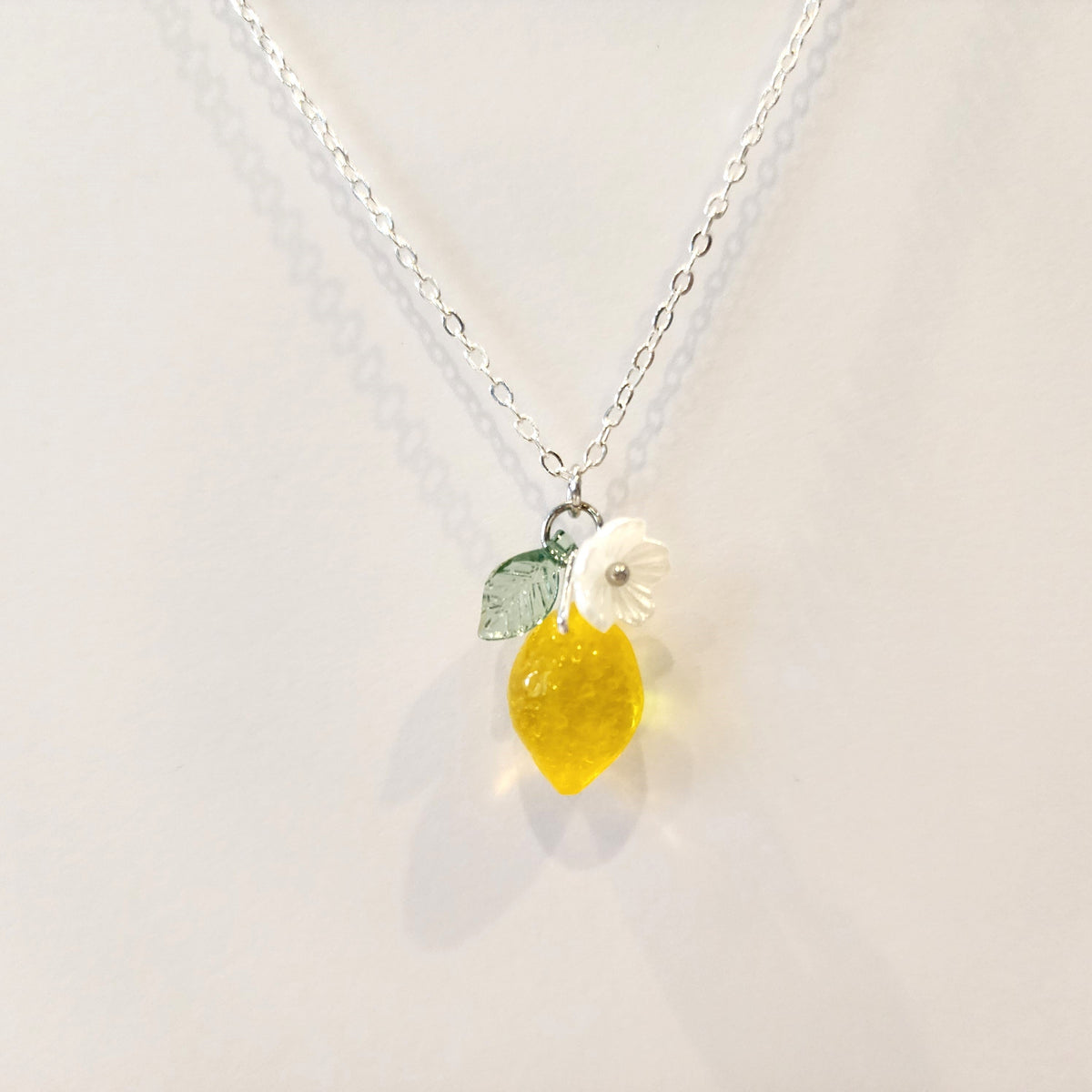 Silver chain lemon pendant necklace with yellow lemon charm and white flower