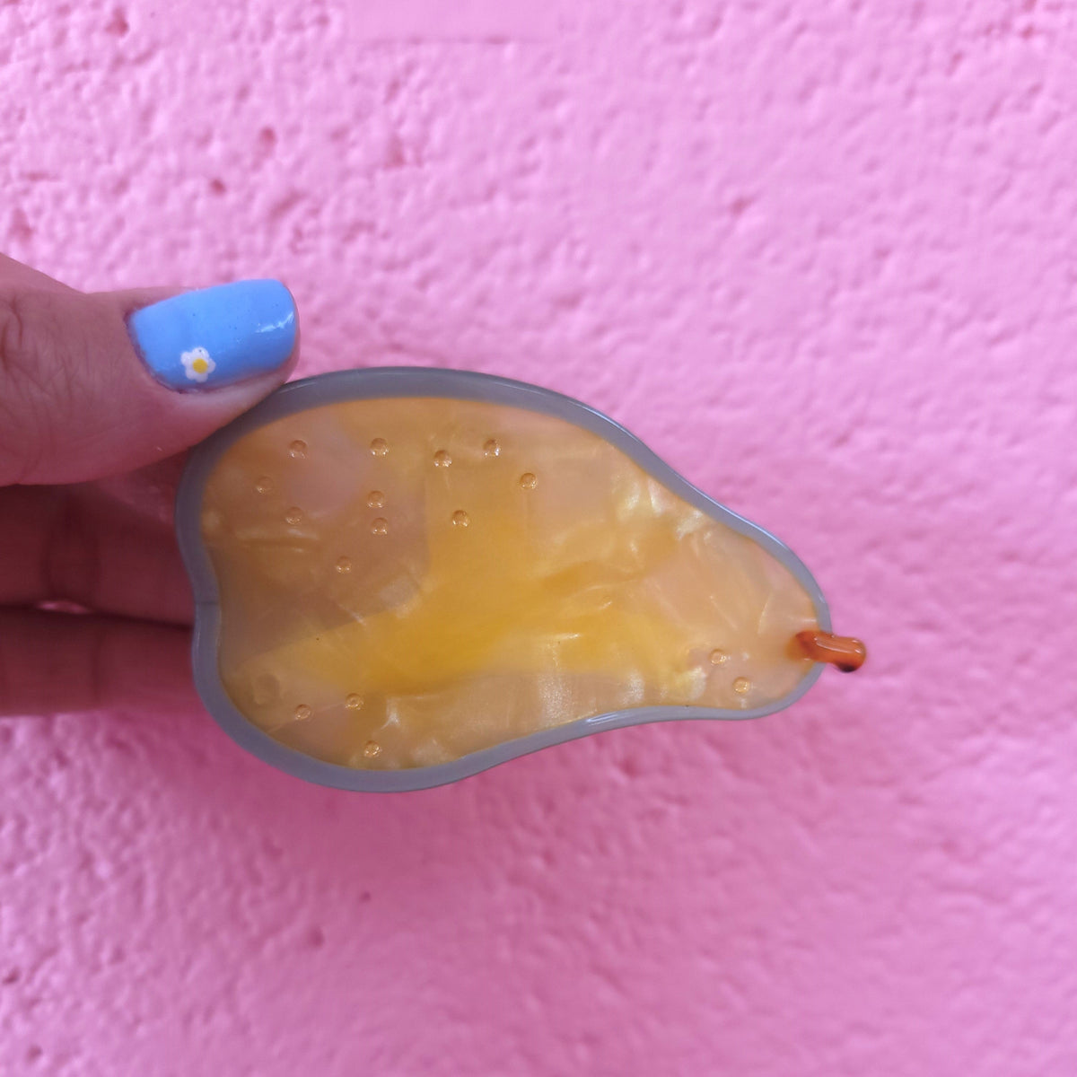 Yellow citrus fruit hair claw with translucent jelly texture and brown tip