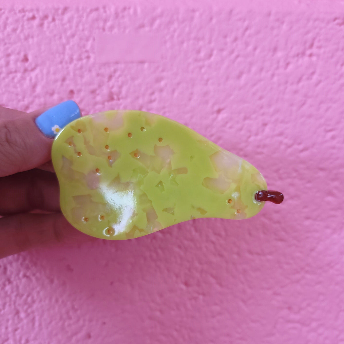 Green citrus fruit hair claw with translucent jelly texture and brown stem