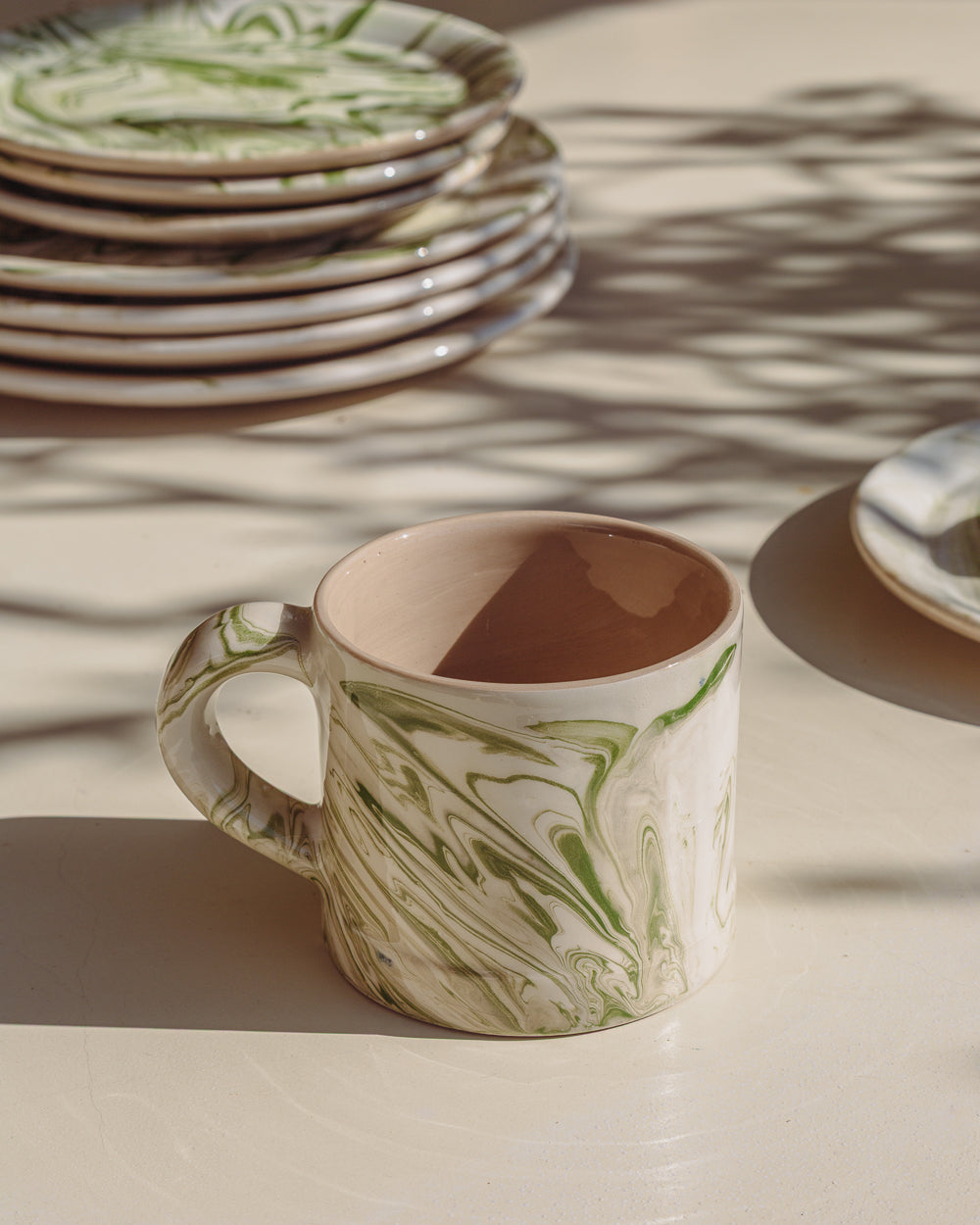Marbled olive mug in cream with green marbled waves, dark interior