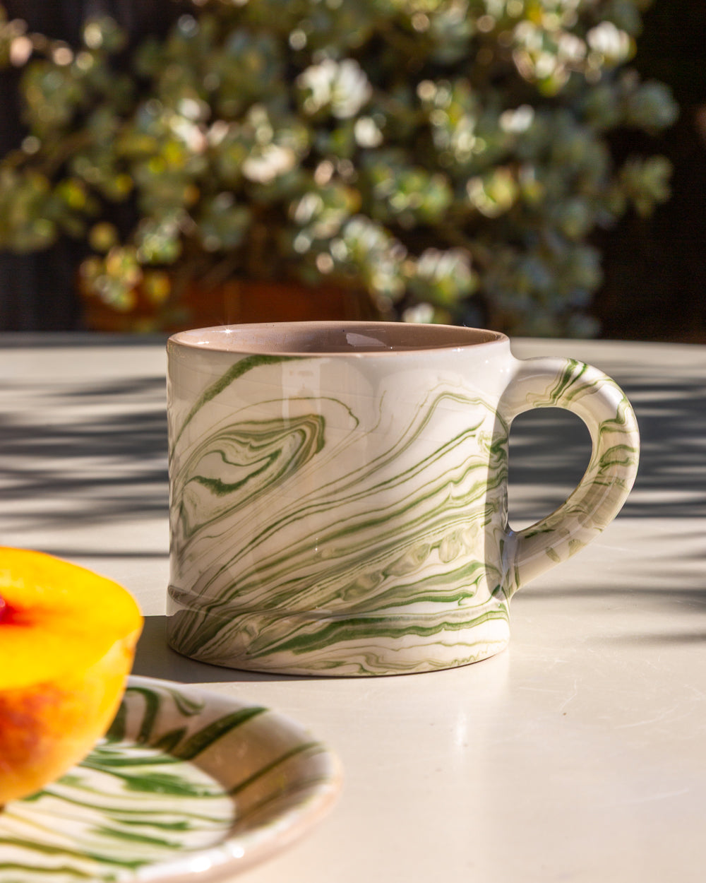 Marbled olive mug with green swirls on a cream body, wide rim and handle
