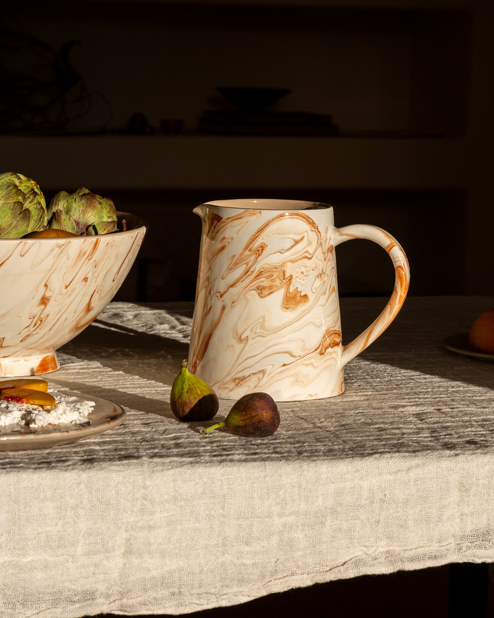 Marbled terra ceramic pitcher with curved handle, white base with orange-brown marbling