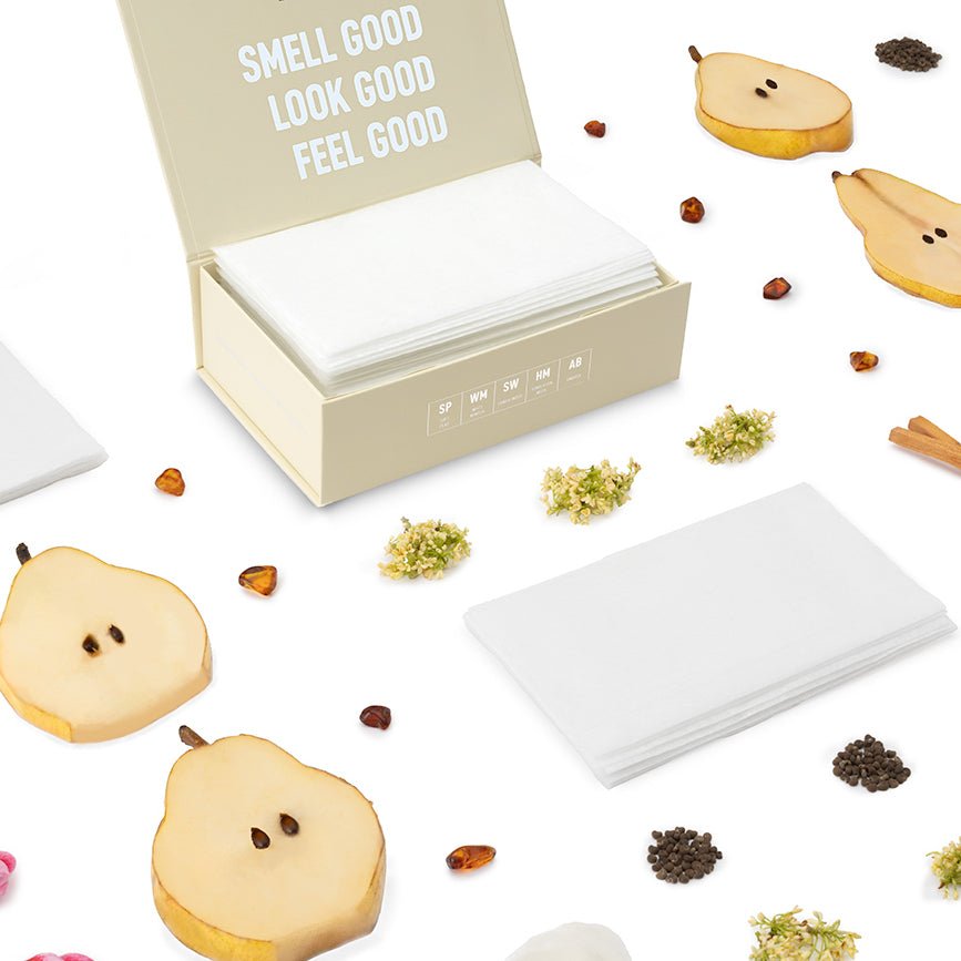 Luxury scented dryer sheets in a cream open box with stacked white sheets and scattered sheets.