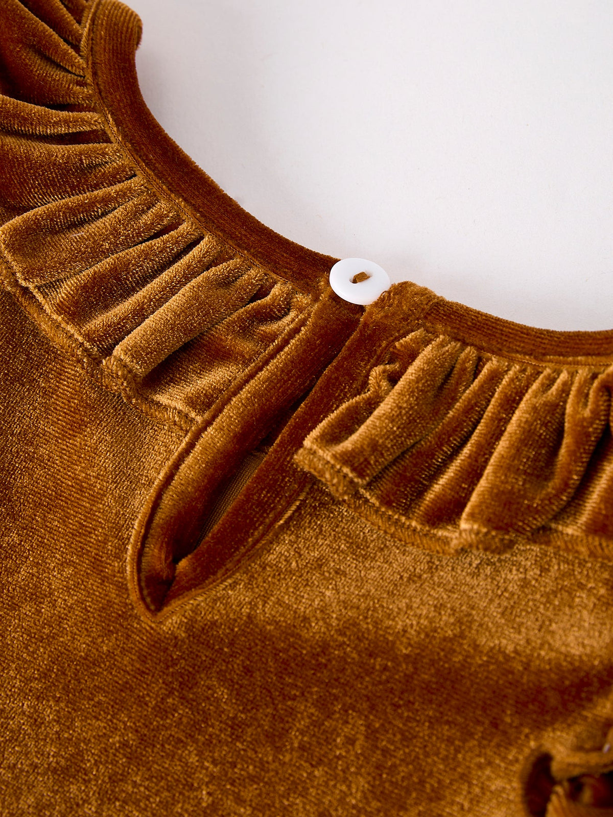 Girls velvet dress neckline detail in brown-gold with small button closure