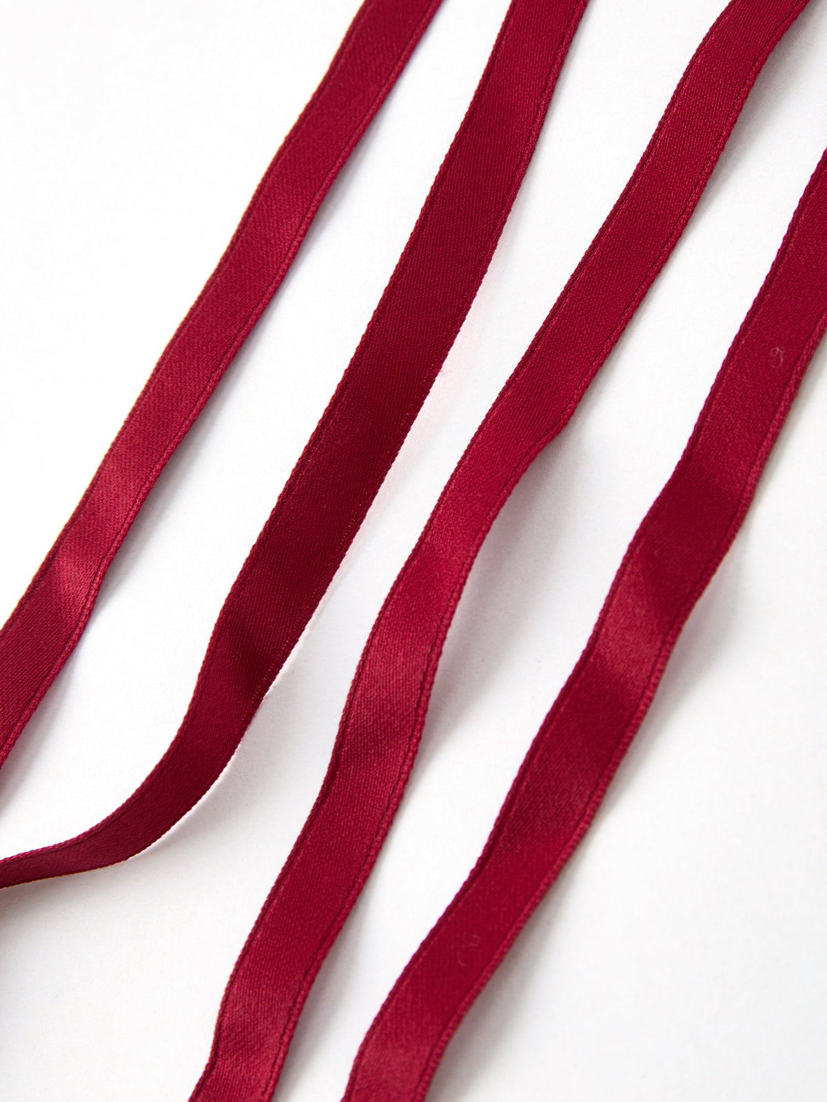 Long burgundy ribbon streamers on the cherry bow hairpin