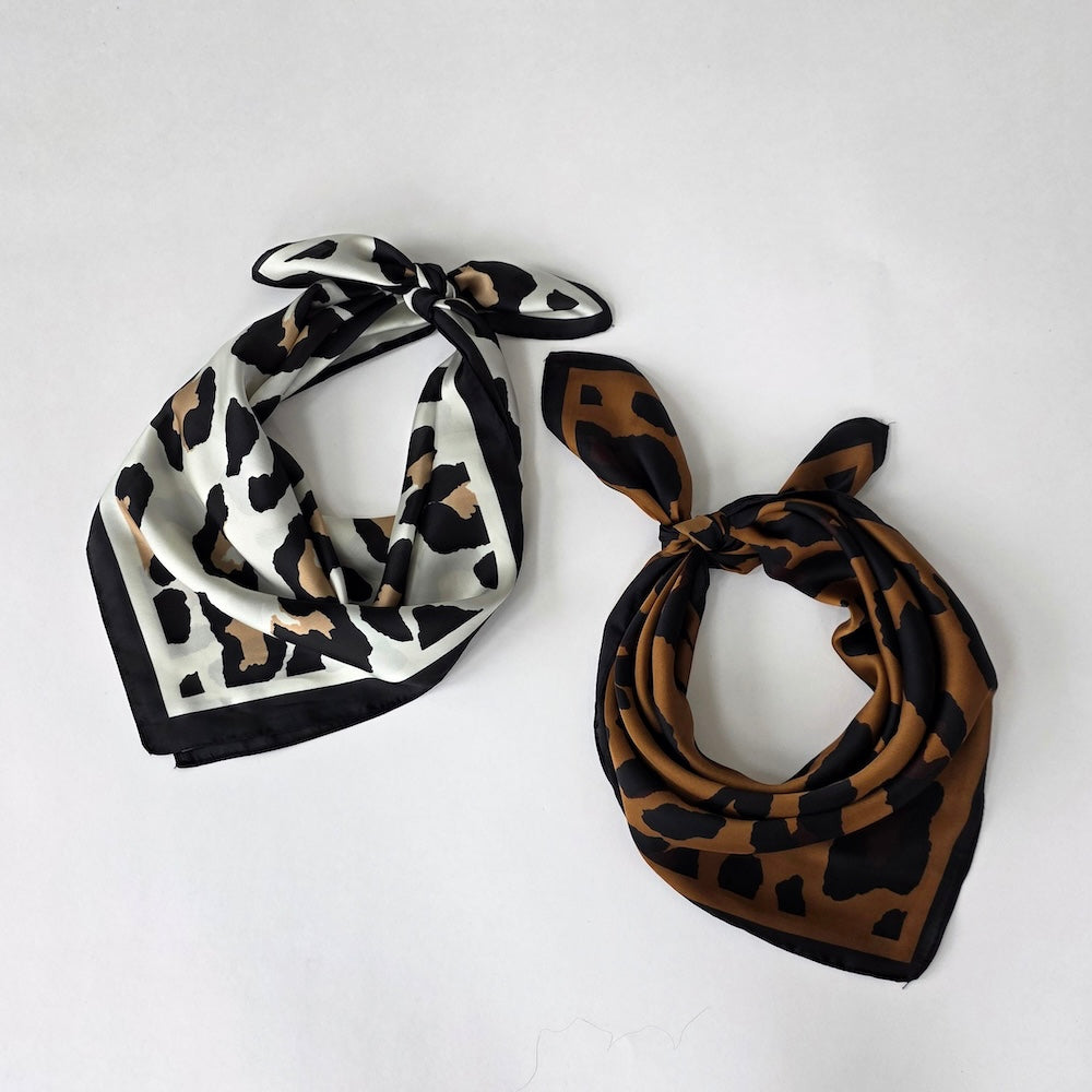 Pair of leopard square scarves: black/cream and black/brown, tied bow style
